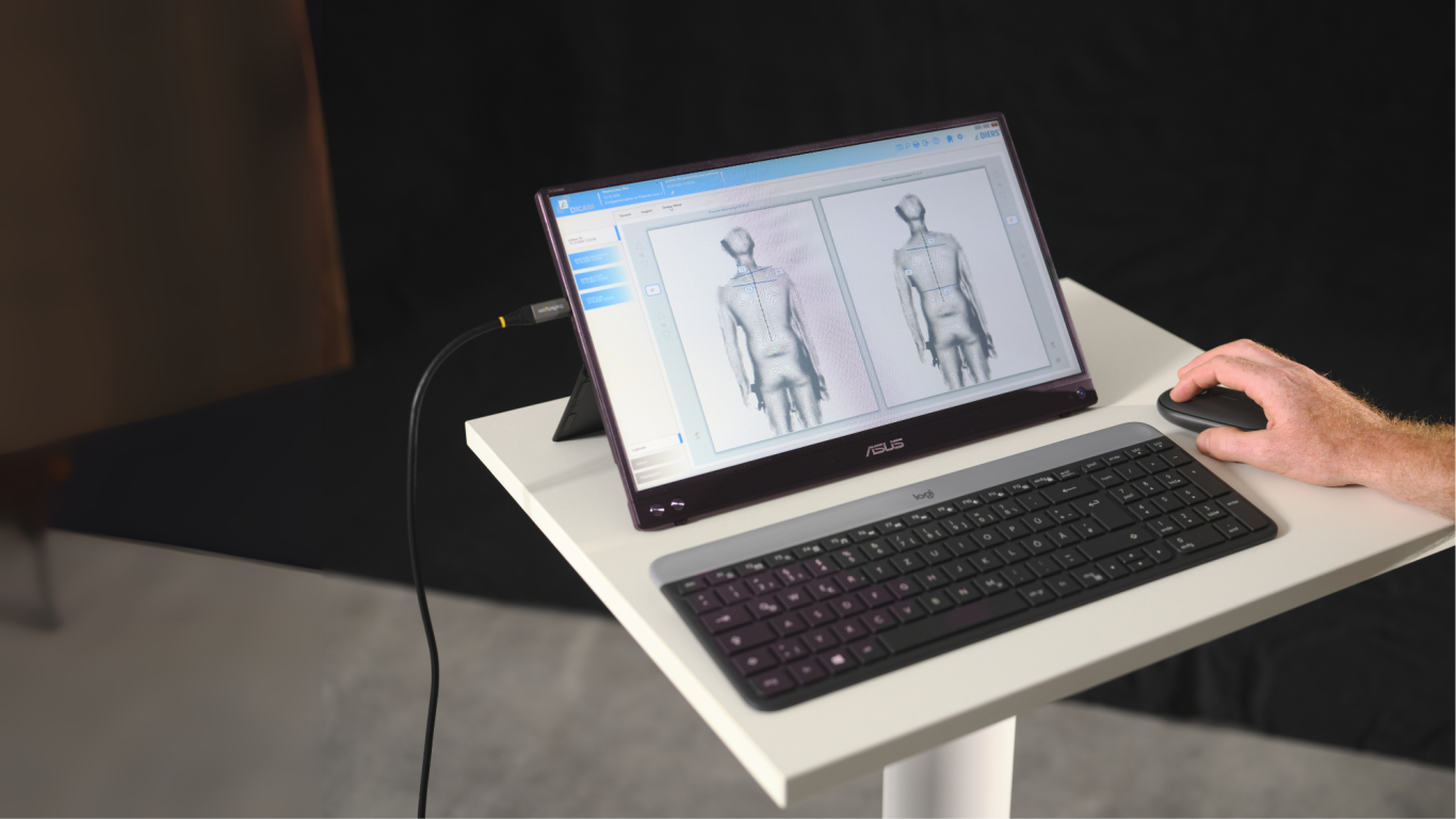 Laptop mit Bildschirm, der zwei menschliche Körperumrisse zeigt, neben einer Hand mit Maus.